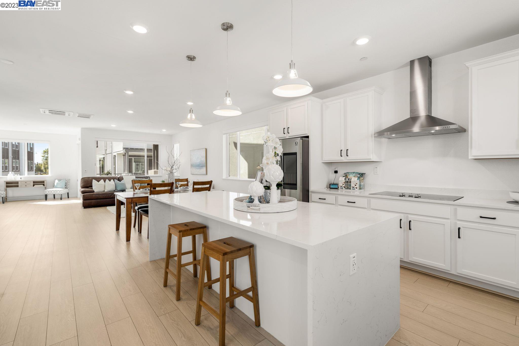 a kitchen with stainless steel appliances a table chairs refrigerator and cabinets