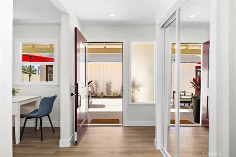 a view of a hallway with wooden floor and a living room