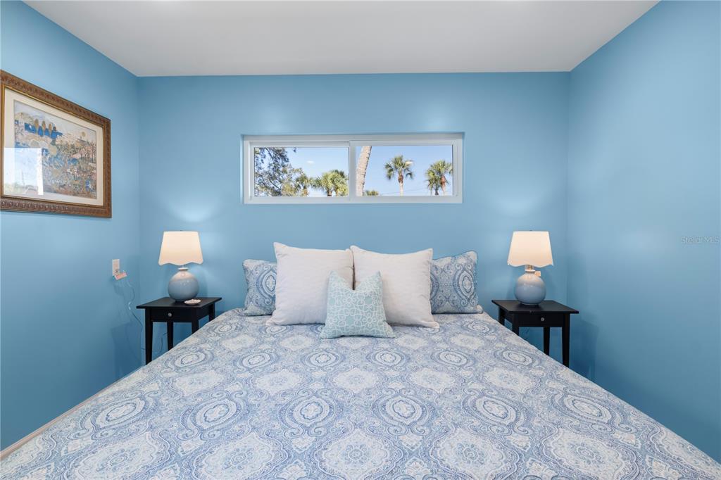 204 29th Street Holmes Beach, FL 34217 - Photo 17 of 38 a bedroom with a bed and a lamp on dresser