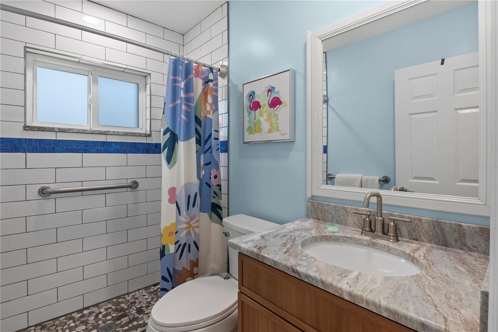 204 29th Street Holmes Beach, FL 34217 - Photo 19 of 38 a bathroom with a granite countertop toilet sink and mirror