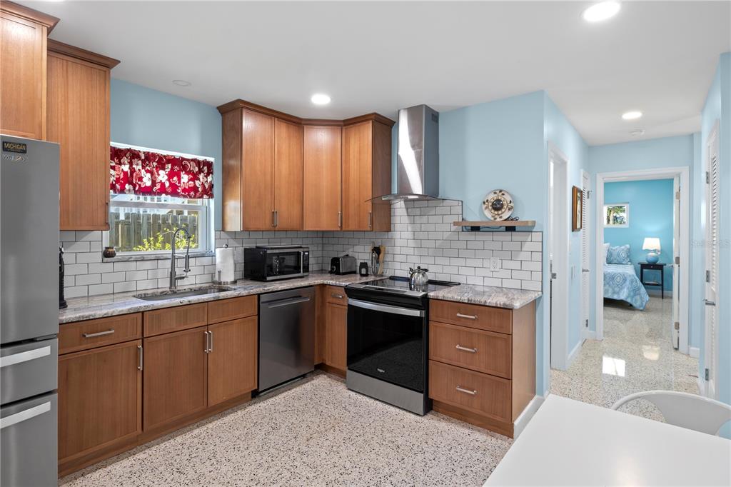 204 29th Street Holmes Beach, FL 34217 - Photo 20 of 38 a kitchen with kitchen island granite countertop a sink cabinets and stainless steel appliances