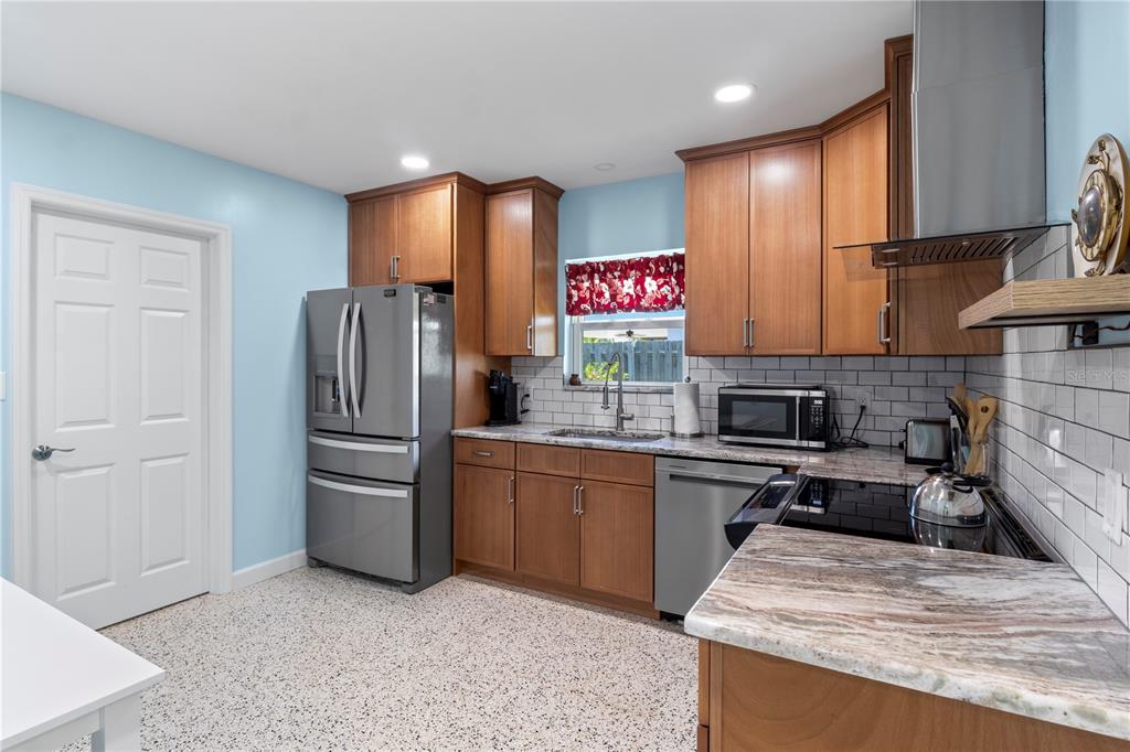 204 29th Street Holmes Beach, FL 34217 - Photo 21 of 38 a kitchen with stainless steel appliances granite countertop a refrigerator sink and stove