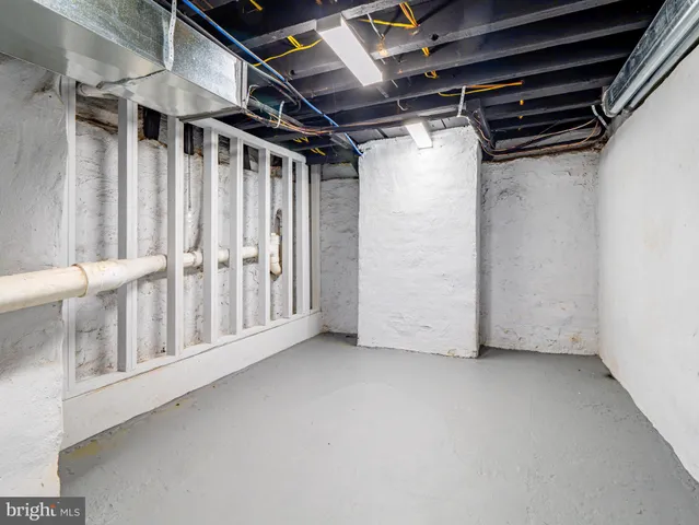 an empty room with wooden floor closet and windows