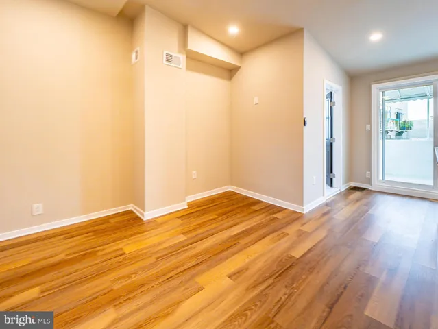 a view of an empty room with wooden floor