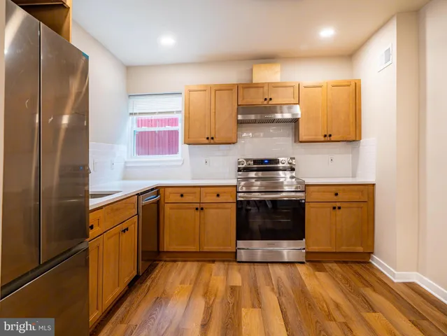 a kitchen with stainless steel appliances a stove a sink and a refrigerator