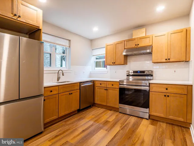 a kitchen with stainless steel appliances granite countertop a stove a sink and a refrigerator