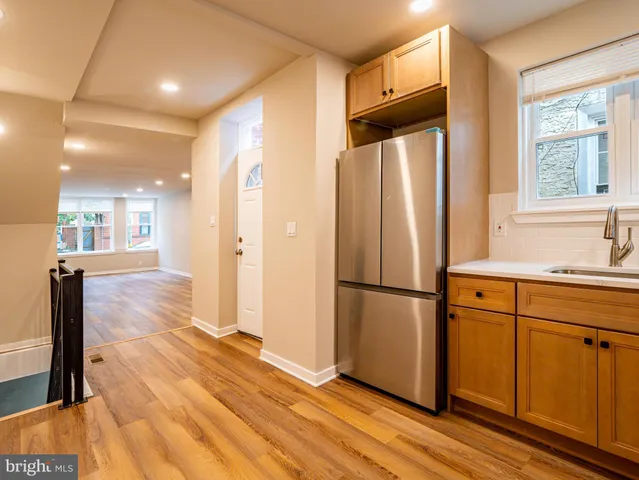 a kitchen with stainless steel appliances a refrigerator sink and wooden floor