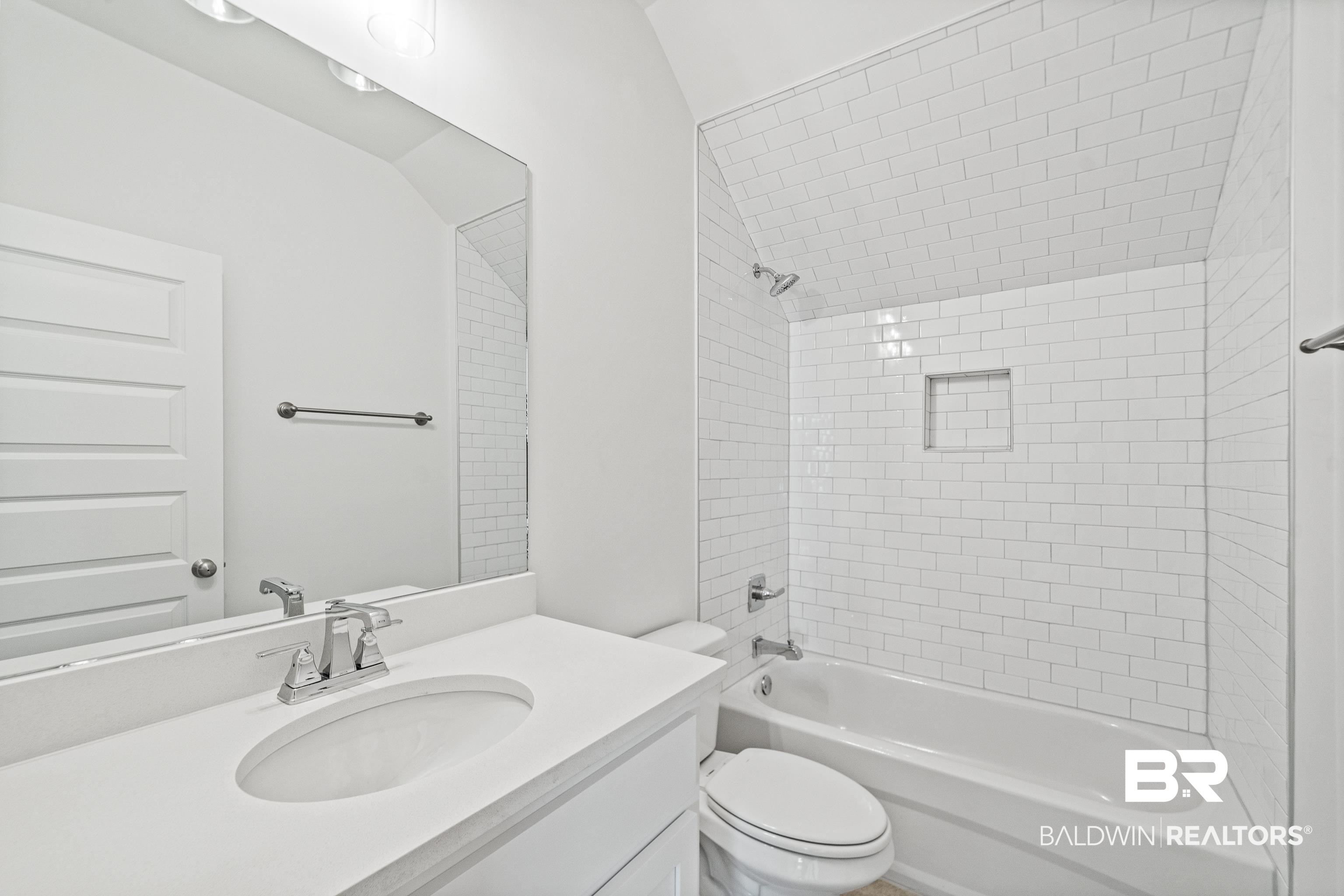 25927 Capra Court Daphne, AL 36526 - Photo 24 of 37 Full bathroom with tiled shower / bath combo, vanity, and toilet
