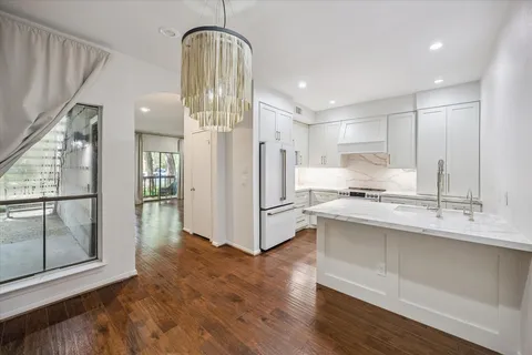 a kitchen with stainless steel appliances a refrigerator and a hard wood floor