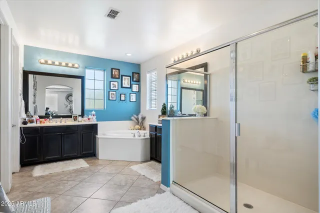 a large bathroom with a large mirror vanity and bathtub