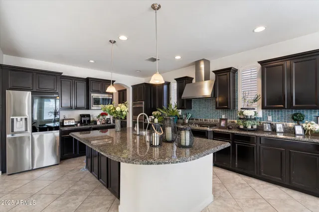 a kitchen with stainless steel appliances granite countertop a sink a stove and a center island
