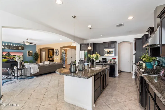 a kitchen with stainless steel appliances granite countertop a sink and a refrigerator