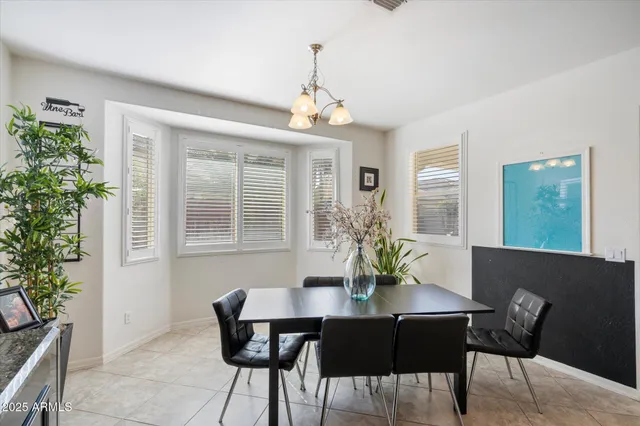 a dining room with furniture potted plants and wooden floor