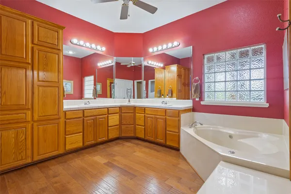 a bathroom with a tub a sink and a large window