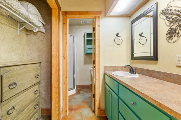 a bathroom with a granite countertop sink mirror and a shower