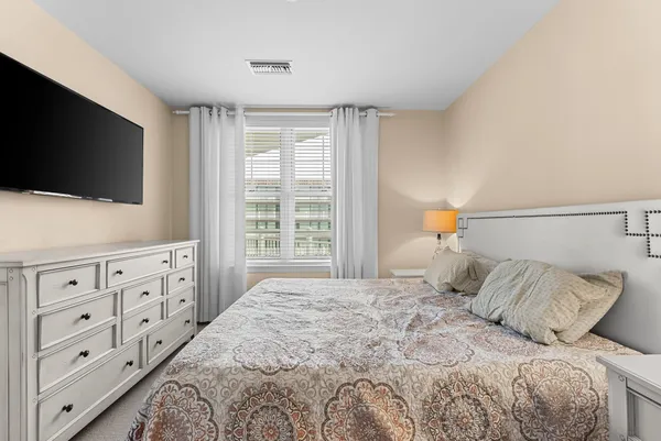a bedroom with a large bed and a flat screen tv