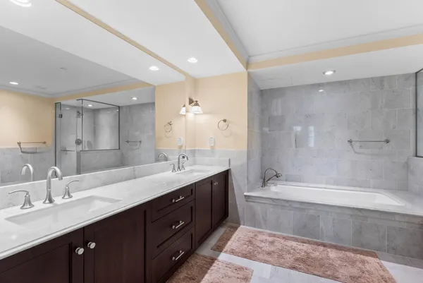 a bathroom with a double vanity sink mirror double and bathtub