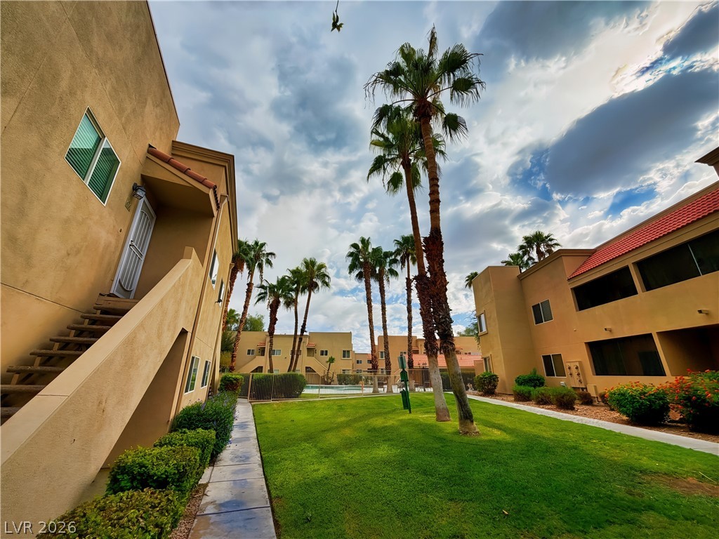 1852 North Decatur Boulevard, Unit 101 Las Vegas, NV 89108 - Photo 18 of 45 Towering palm trees rise from manicured lawns bordered by stucco facades and tiled rooftops.