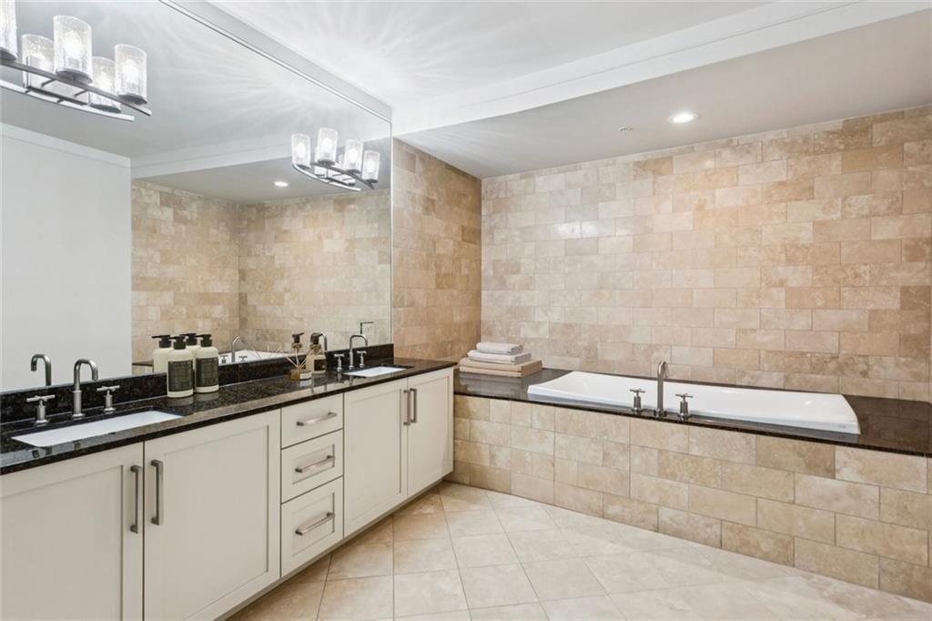 3344 Peachtree Road Northeast, Unit 4104 Atlanta, GA 30326 - Photo 11 of 30 a spacious bathroom with a granite countertop tub sink and mirror