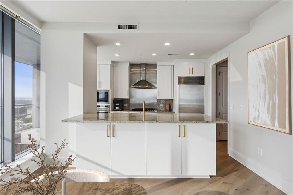 3344 Peachtree Road Northeast, Unit 4104 Atlanta, GA 30326 - Photo 5 of 30 a kitchen with stainless steel appliances kitchen island granite countertop a refrigerator and a sink