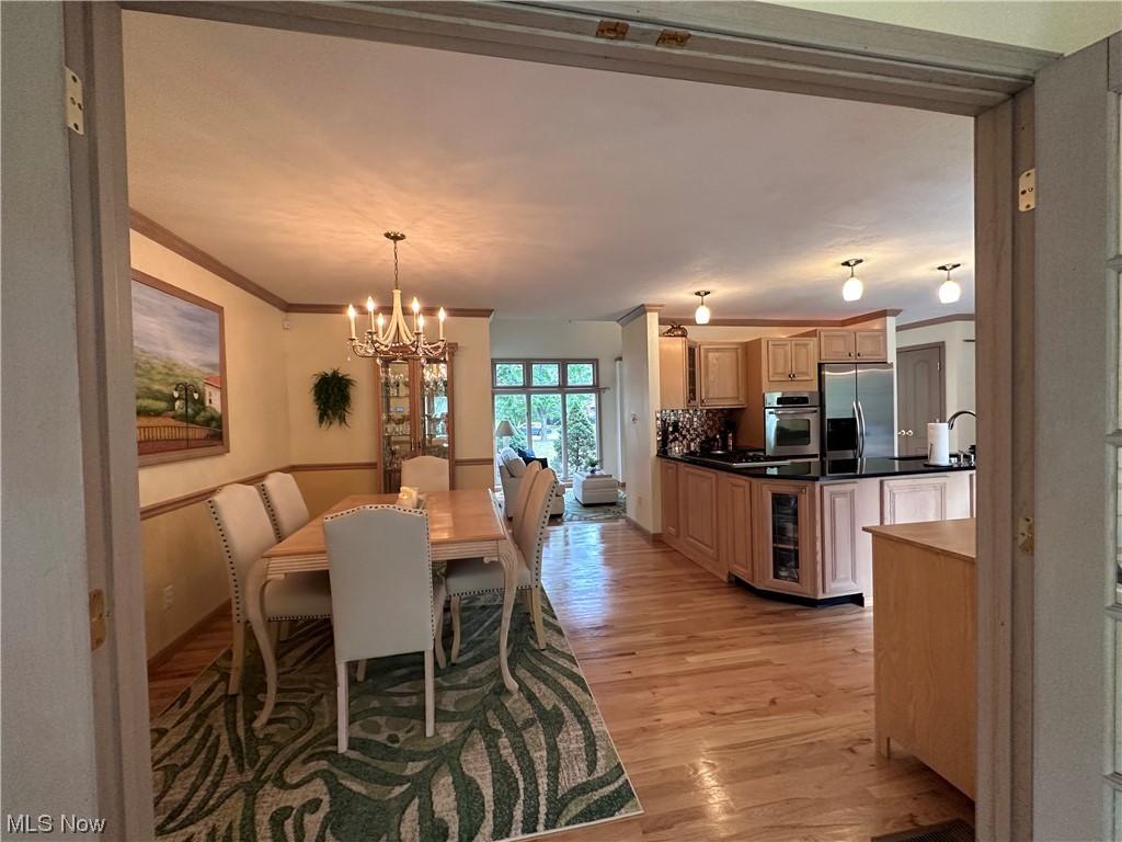 7262 Stone Road Independence, OH 44131 - Photo 17 of 34 Wood floored dining space with a chandelier and crown molding