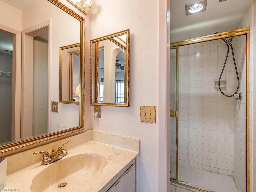 5590 Rattlesnake Hammock Road, Unit M203 Naples, FL 34113 - Photo 11 of 22 a bathroom with a granite countertop sink and a mirror