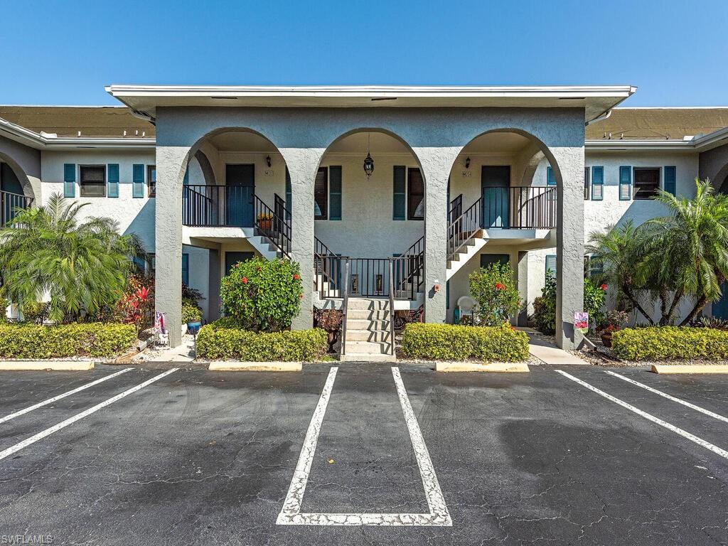 5590 Rattlesnake Hammock Road, Unit M203 Naples, FL 34113 - Photo 2 of 22 a front view of a house with garden
