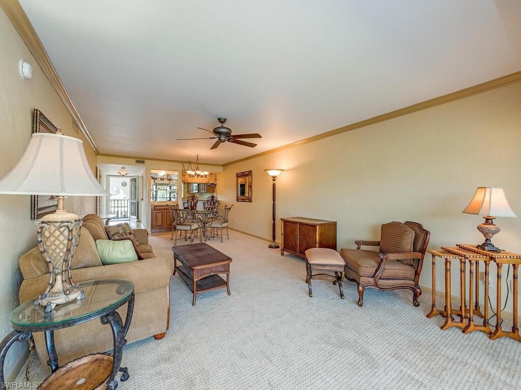 5590 Rattlesnake Hammock Road, Unit M203 Naples, FL 34113 - Photo 4 of 22 a living room with furniture and a lamp