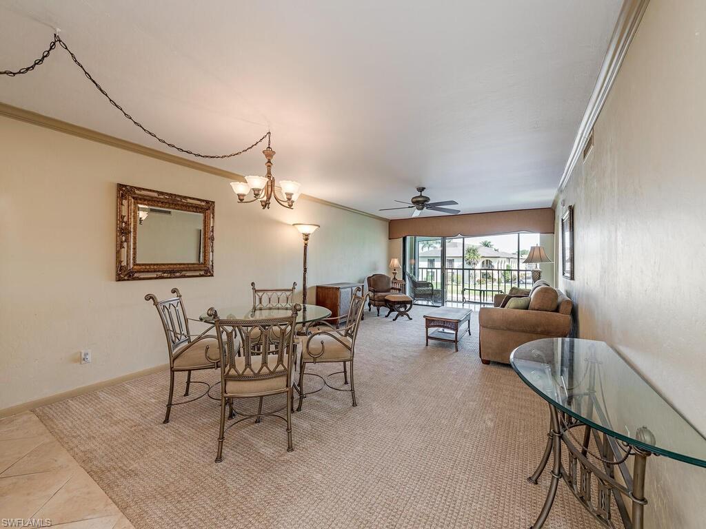 5590 Rattlesnake Hammock Road, Unit M203 Naples, FL 34113 - Photo 5 of 22 a living room with furniture and a large window