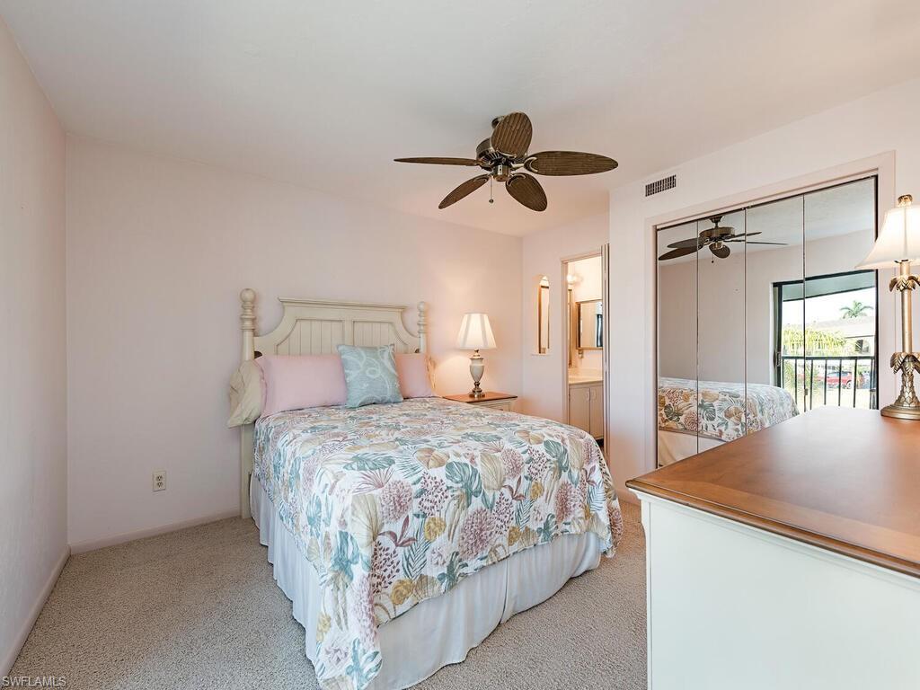 5590 Rattlesnake Hammock Road, Unit M203 Naples, FL 34113 - Photo 8 of 22 a bedroom with a bed and a chandelier