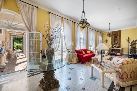 a living room with patio furniture and a chandelier