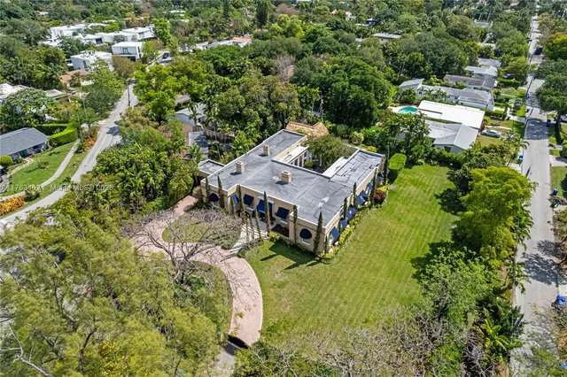 an aerial view of residential house with outdoor space and trees all around
