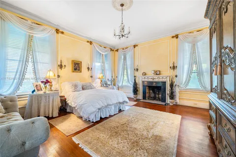 a spacious bedroom with a bed a chandelier and couch