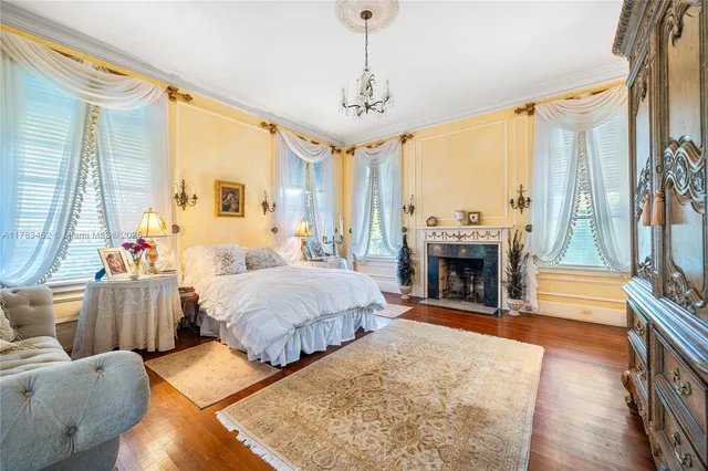 a spacious bedroom with a bed a chandelier and couch