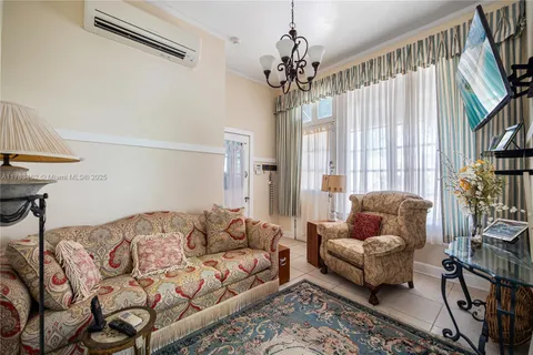 a living room with furniture a chandelier and a window