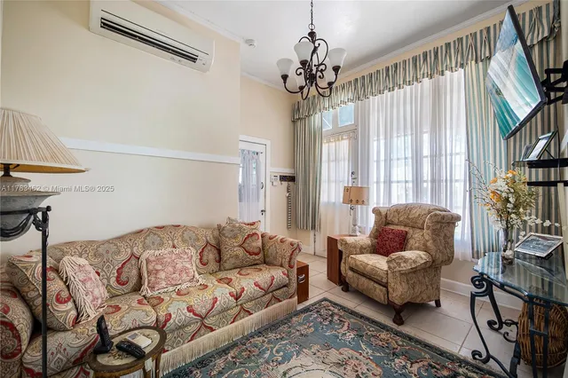 a living room with furniture a chandelier and a window