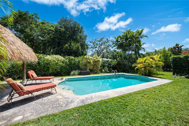 a view of a swimming pool with a lounge chair and grass