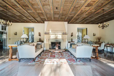 a living room with a fireplace furniture and a chandelier