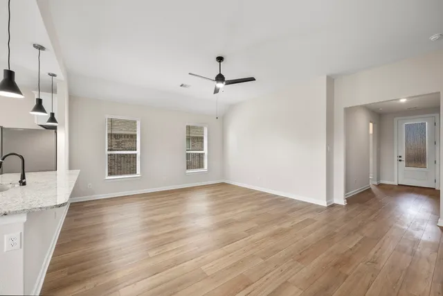 a view of a kitchen with wooden floor and a ceiling fan