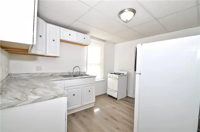 a view of a kitchen with sink and refrigerator