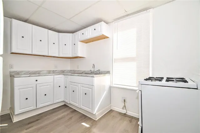 a kitchen with granite countertop white cabinets and white appliances