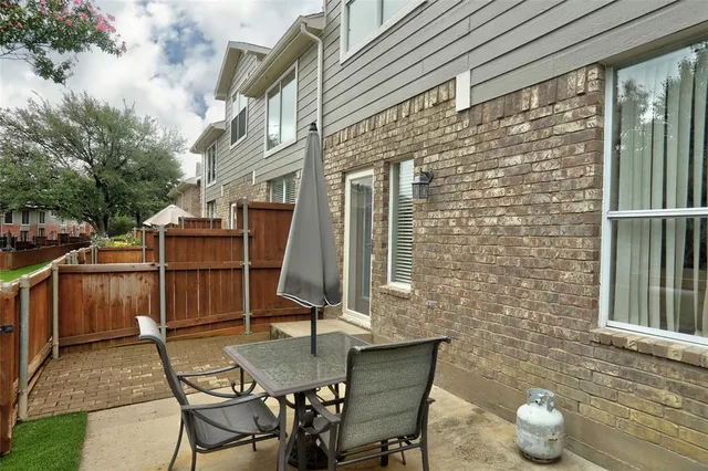 a backyard of a house with table and chairs