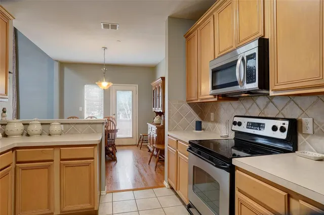 a kitchen with stainless steel appliances granite countertop a stove microwave and refrigerator
