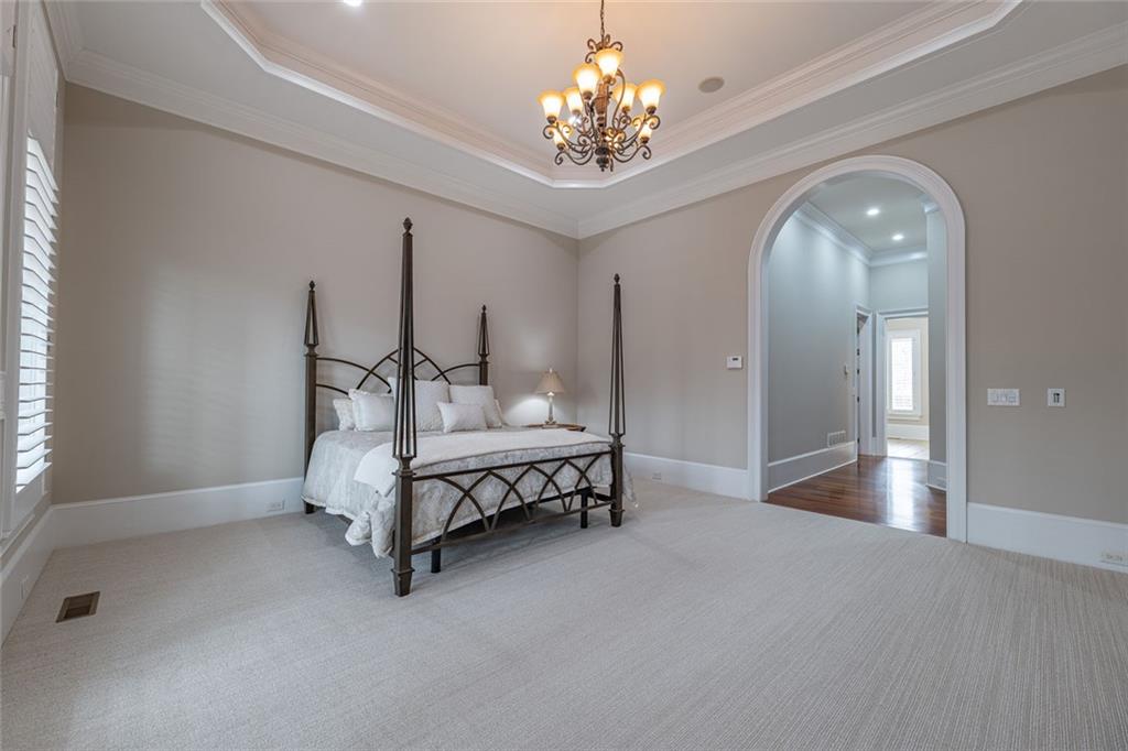 250 Frank Bruce Road Dawsonville, GA 30534 - Photo 24 of 110 a spacious bedroom with a bed and a chandelier