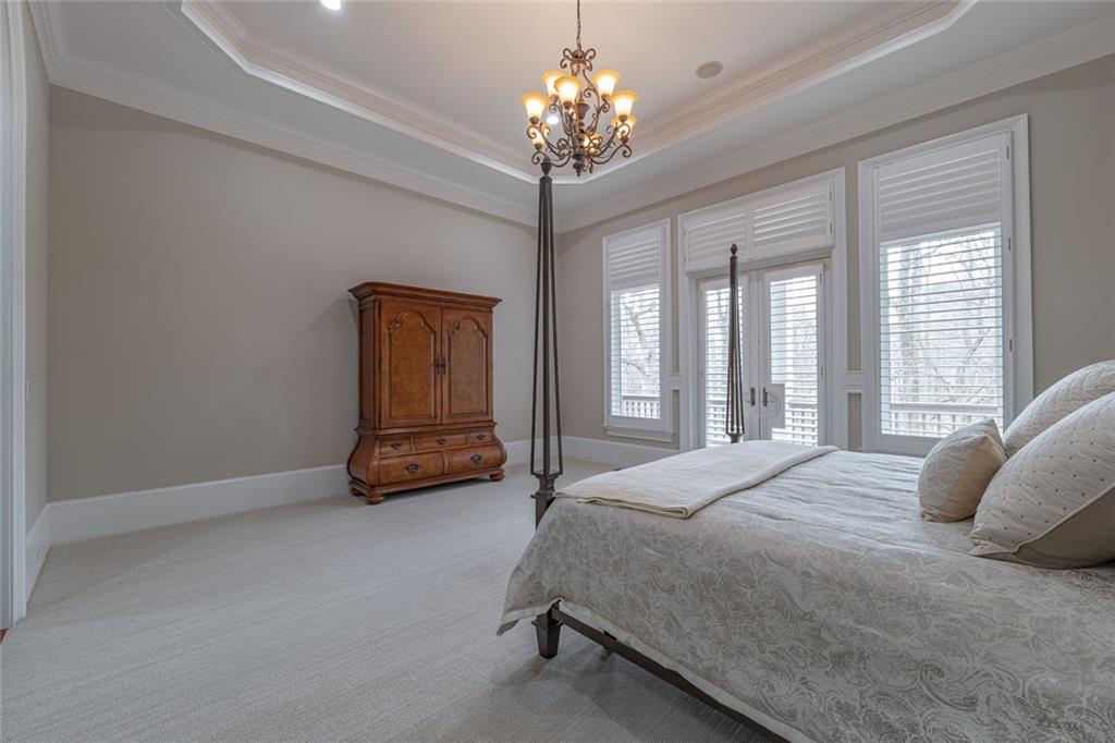 250 Frank Bruce Road Dawsonville, GA 30534 - Photo 26 of 110 a bedroom with a bed and a chandelier