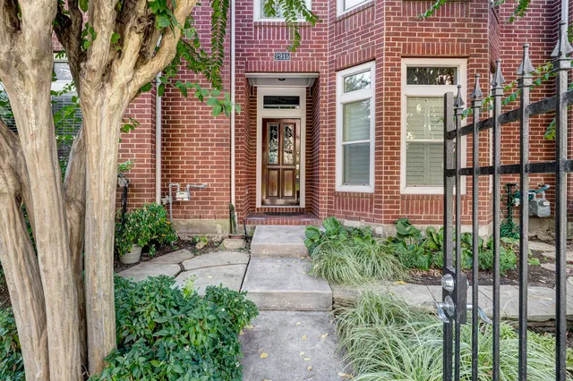 a front view of a house with a yard and potted plants