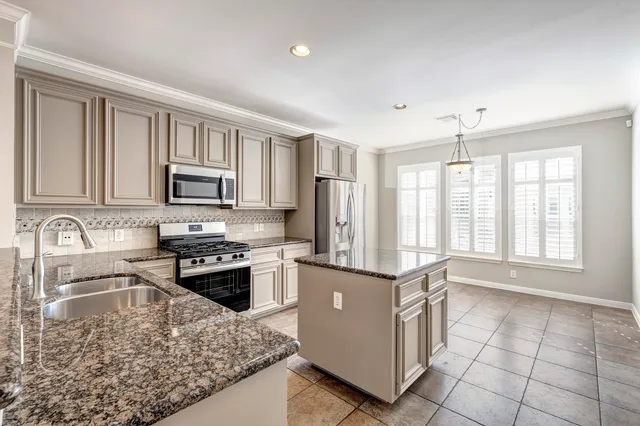 a kitchen with stainless steel appliances granite countertop a stove top oven a sink a counter space and cabinets