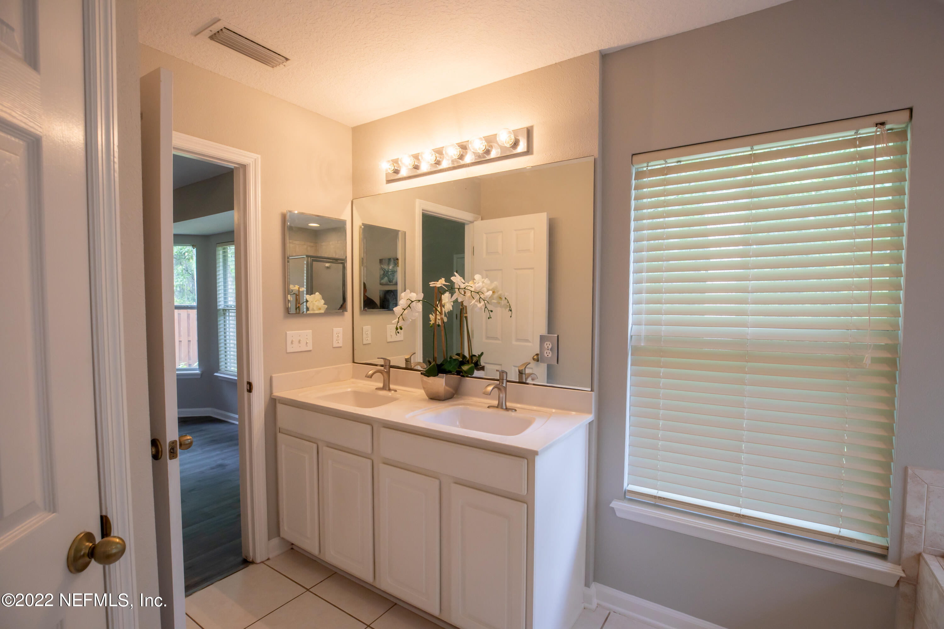 2067 North Cranbrook Avenue St. Augustine, FL 32092 - Photo 18 of 26 a bathroom with a sink a mirror and a shower