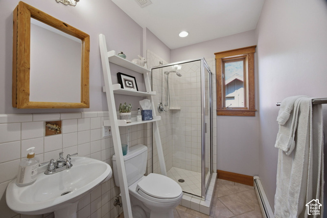 725 Canyon Road Smithfield, UT 84335 - Photo 66 of 100 Pedestal sink with chrome fixtures, wood-framed mirror, white subway tile wainscoting, glass-enclosed shower with white tiled walls, and a wood-trimmed window