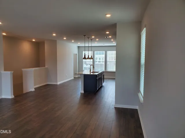 a view of a big room with wooden floor and windows